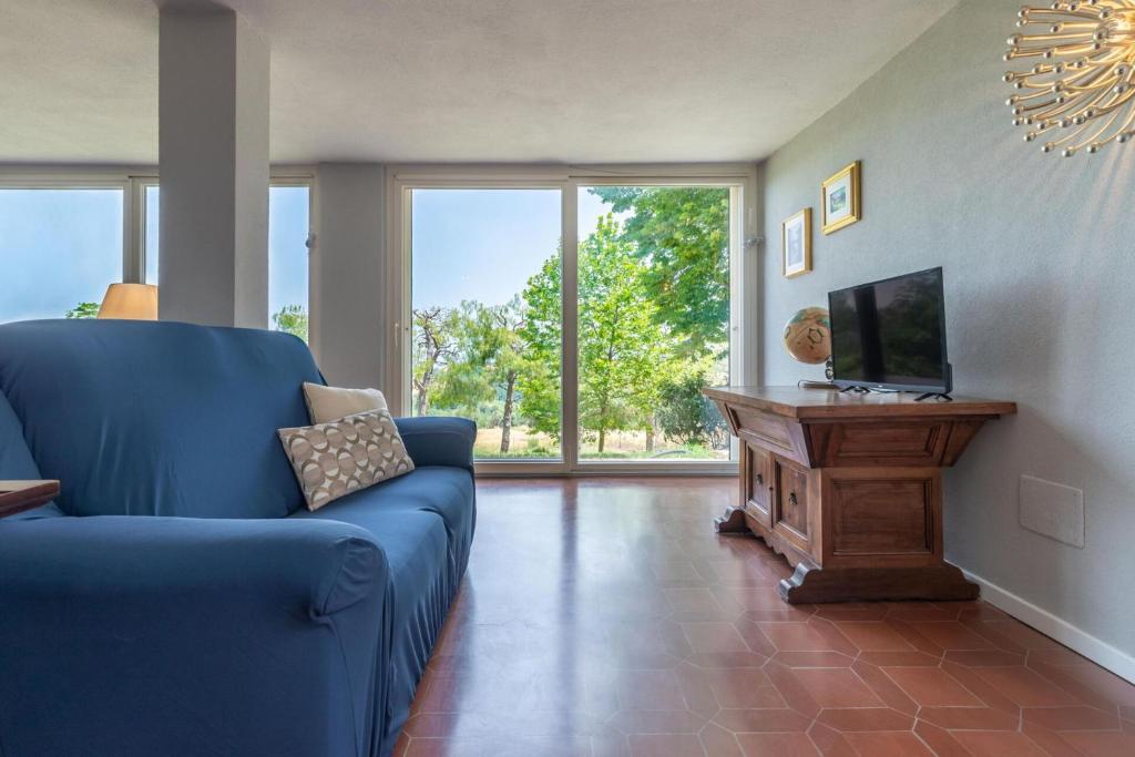 un salon avec un canapé bleu et une télévision dans l'établissement Villa degli Archi by Mmega, à SantʼElpidio a Mare
