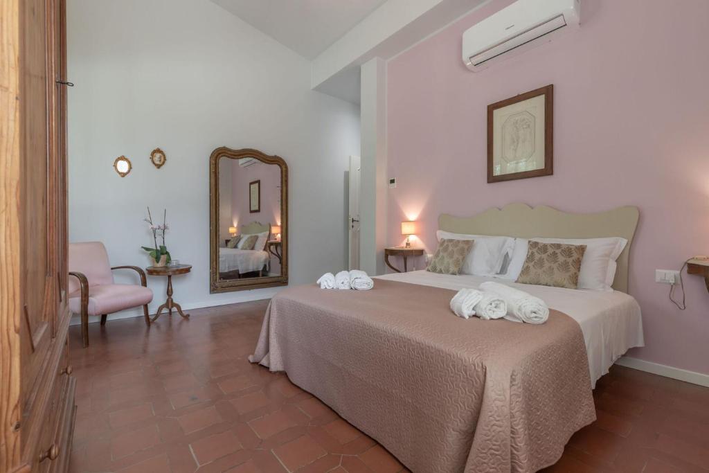 une chambre avec un grand lit avec des serviettes dessus dans l'établissement Villa degli Archi by Mmega, à SantʼElpidio a Mare