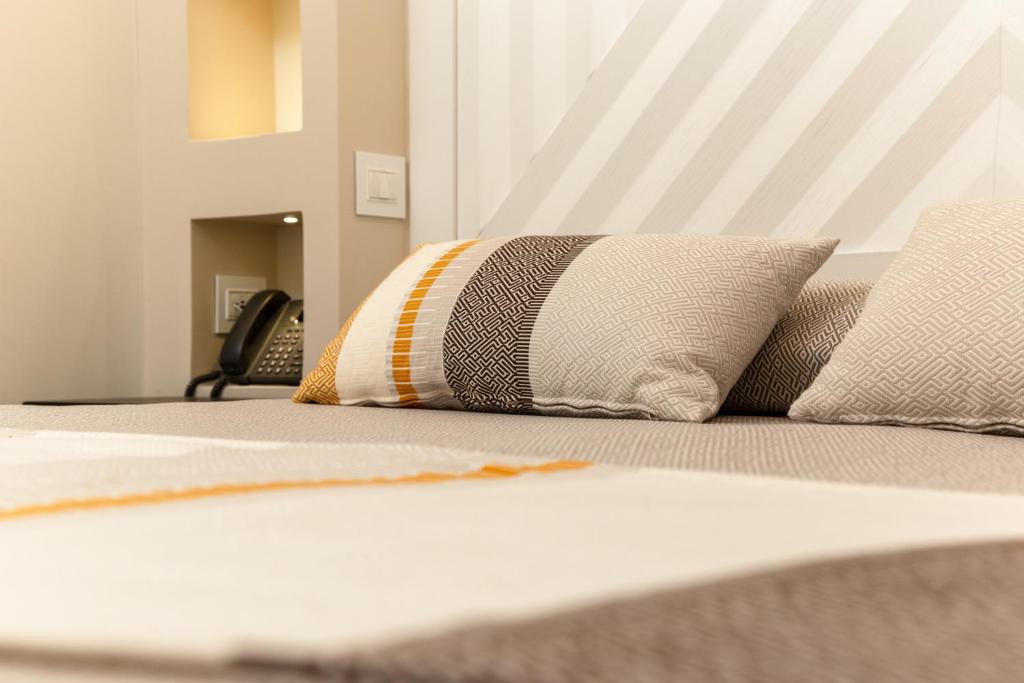 un lit avec deux oreillers dessus dans une chambre dans l'établissement Hotel Club Saraceno - Bovis Hotels, à Àrbatax 192 autres photos