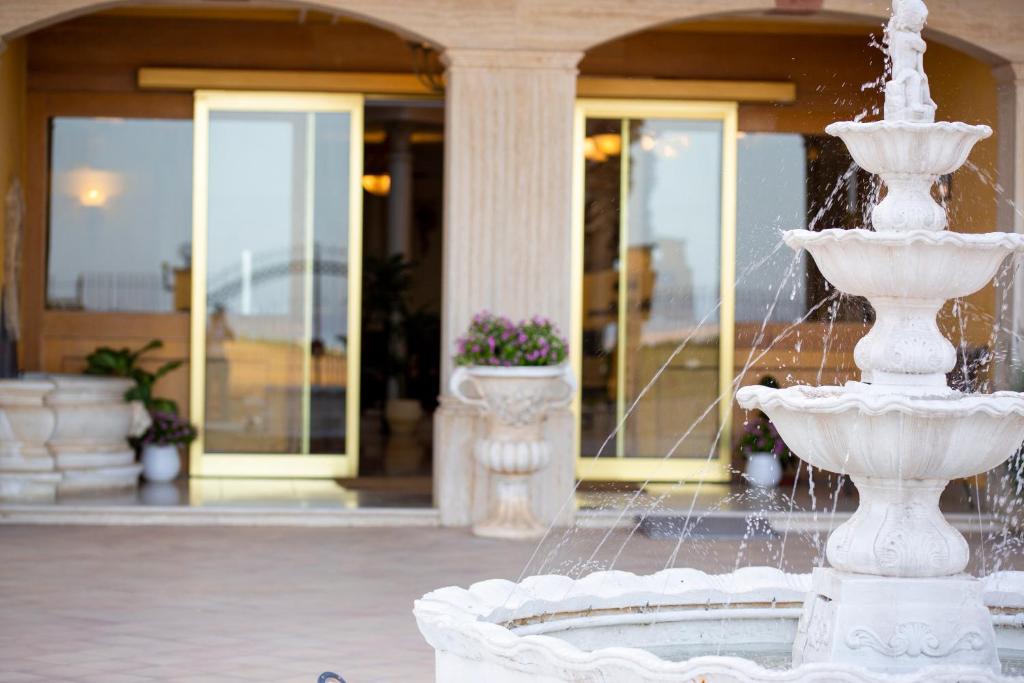 une fontaine blanche devant un bâtiment dans l'établissement Hotel Villa Romana, à Porto Empedocle