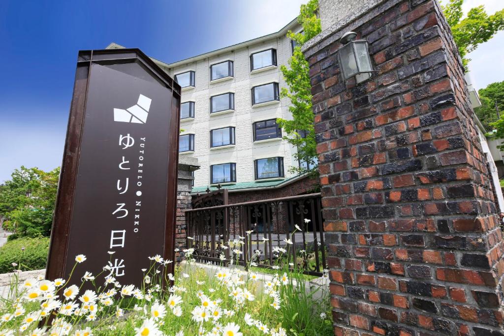 un panneau d'hôtel devant un bâtiment en briques dans l'établissement Yutorelo Nikko, à Nikkō
