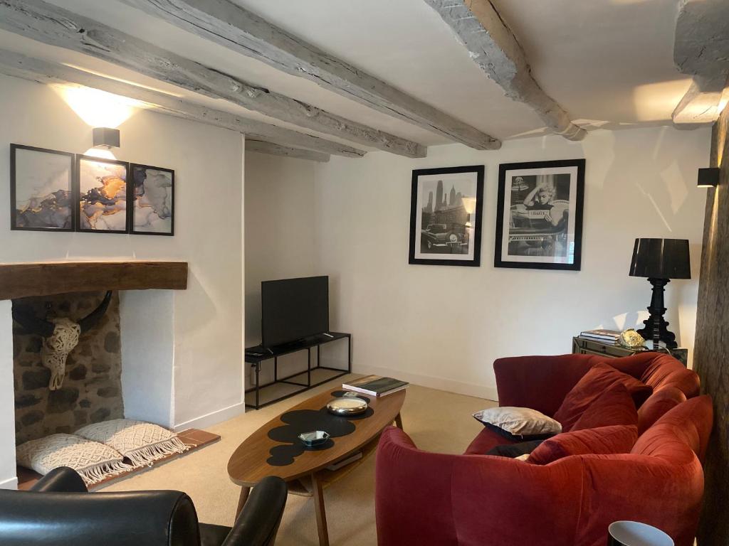 un salon avec un canapé et une table dans l'établissement GÎTES LA FORESTERIE, à Ladignac-le-Long