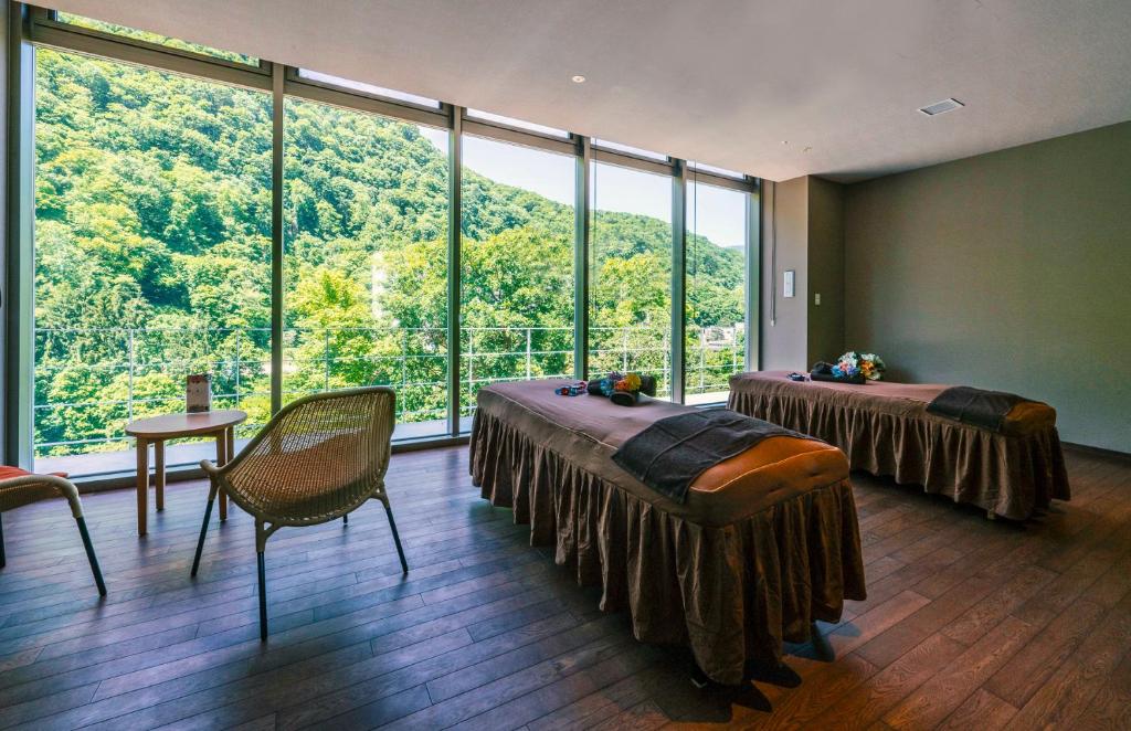 Cette chambre comprend deux lits et une grande fenêtre. dans l'établissement Grand Blissen Hotel Jozankei, à Jozankei