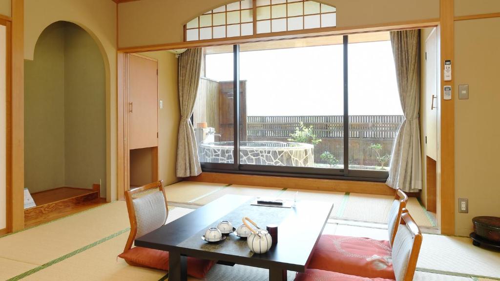 une salle à manger avec une table et une grande fenêtre dans l'établissement Hotel Koryu, à Fujikawaguchiko
