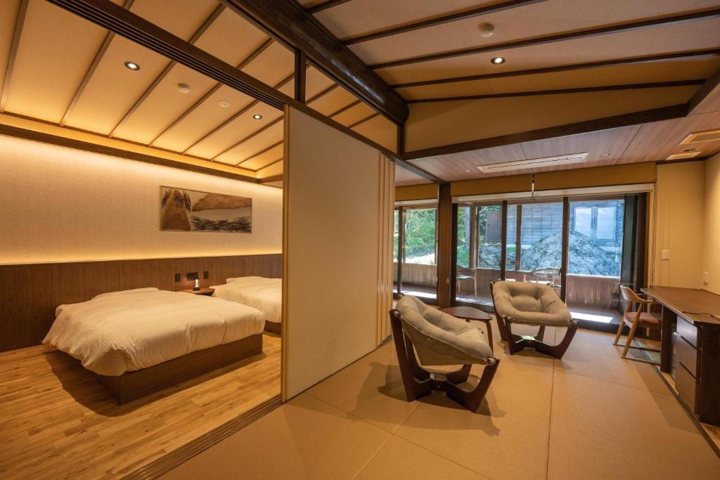 une chambre avec un lit, un bureau et des chaises dans l'établissement Rankeisou, à Sanjo