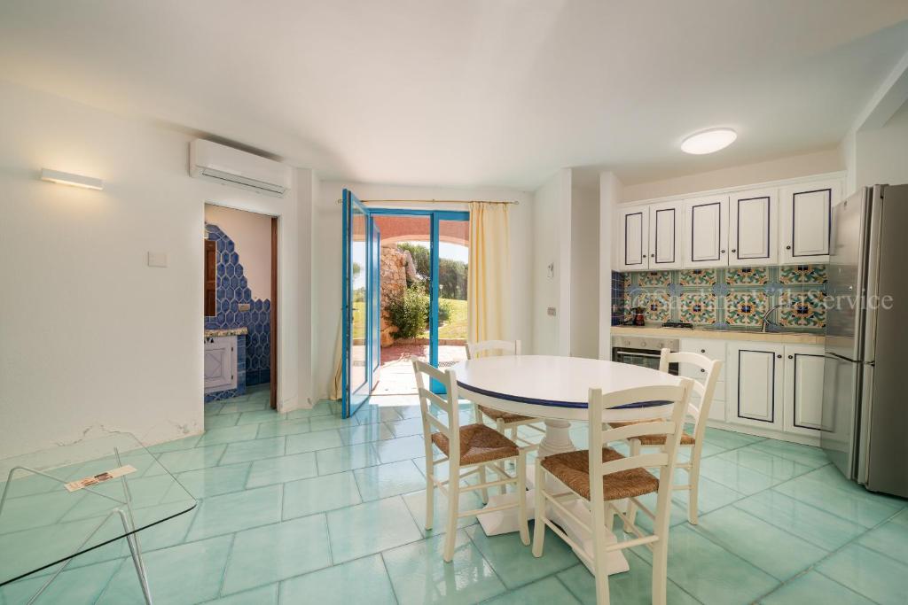 une cuisine et une salle à manger avec une table et des chaises dans l'établissement Villa Corallina - Porto Cervo, à Porto Cervo