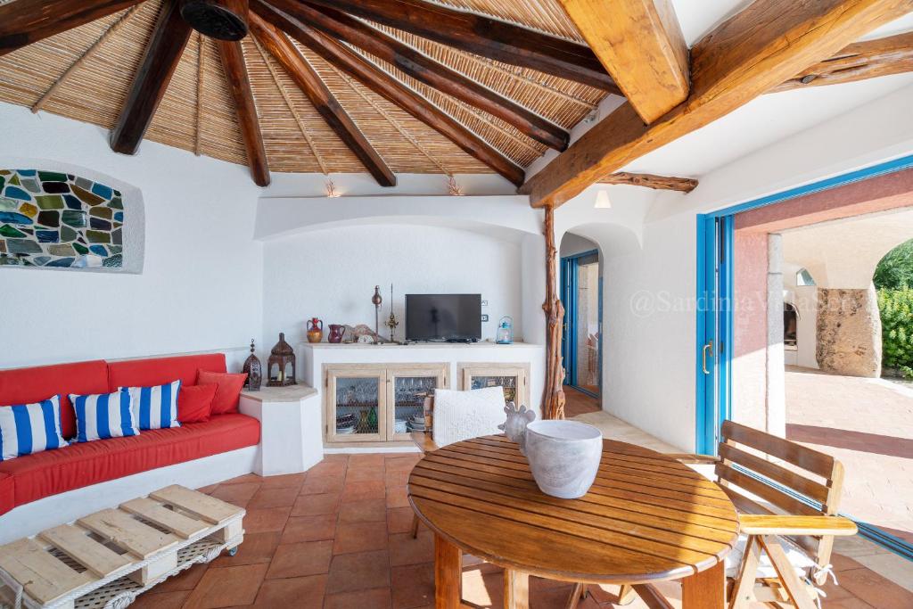 un salon avec un canapé rouge et une table en bois dans l'établissement Villa Corallina - Porto Cervo, à Porto Cervo