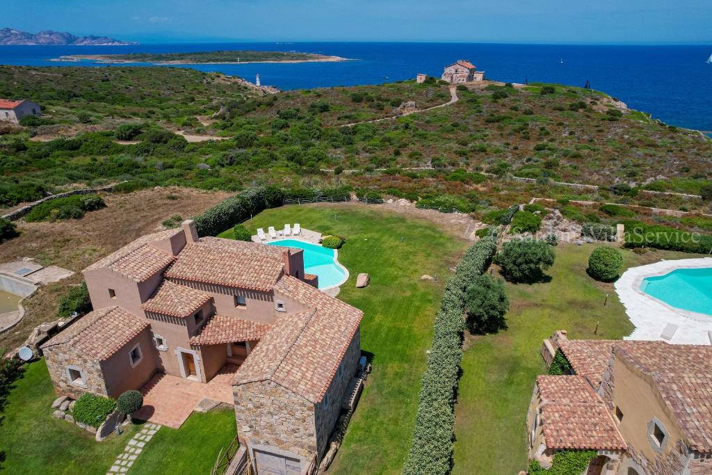 - une vue aérienne sur une maison sur une colline avec une piscine dans l'établissement Villa Del Faro - Porto Cervo, à Porto Cervo