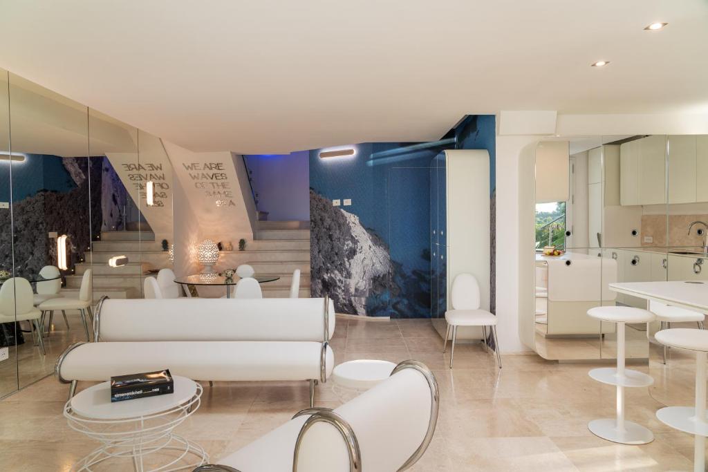 Il comprend un salon avec un mobilier blanc et une cuisine. dans l'établissement Villa Puntaldia, à Puntaldia