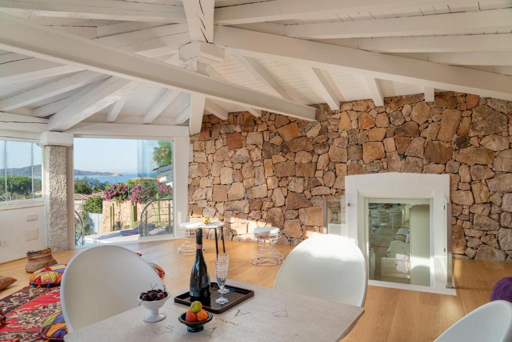 - un salon avec un mur en pierre, une table et des chaises dans l'établissement Villa Puntaldia, à Puntaldia