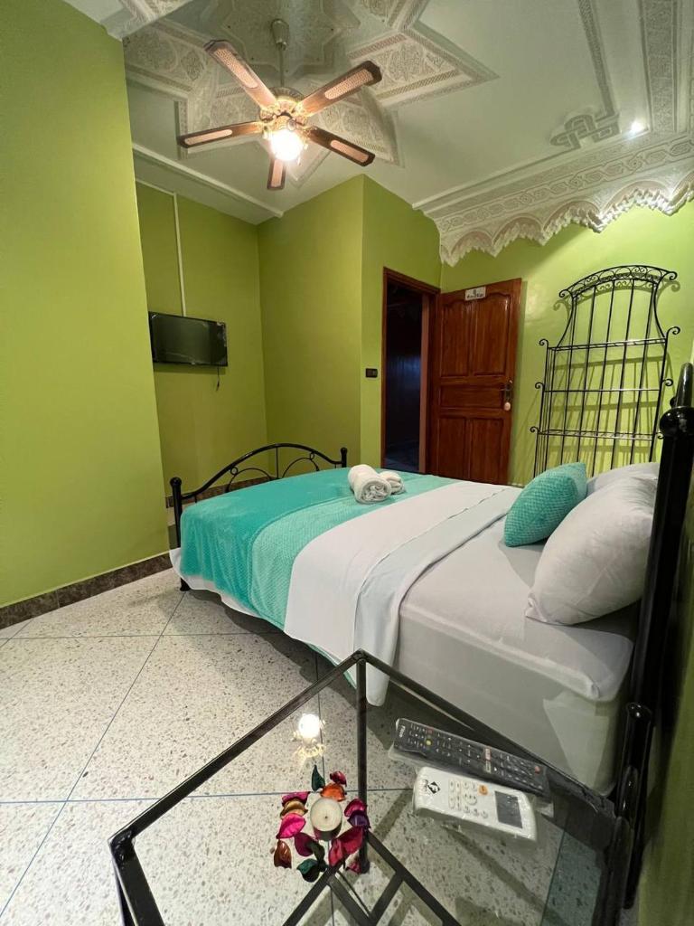 - une chambre avec un lit aux murs verts et un plafond dans l'établissement Riad Perlamazigh, à Zagora