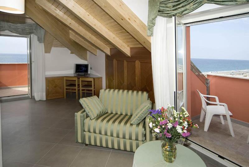 un salon avec un canapé et une table avec des fleurs dans l'établissement Hotel Lido, à Deiva Marina