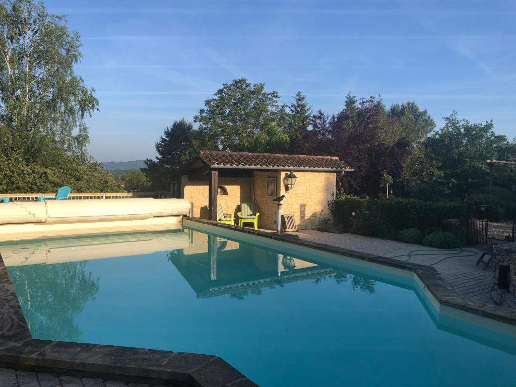 une piscine avec une maison et un bâtiment dans l'établissement le bon chemin roulotte, à Fage 33 autres photos