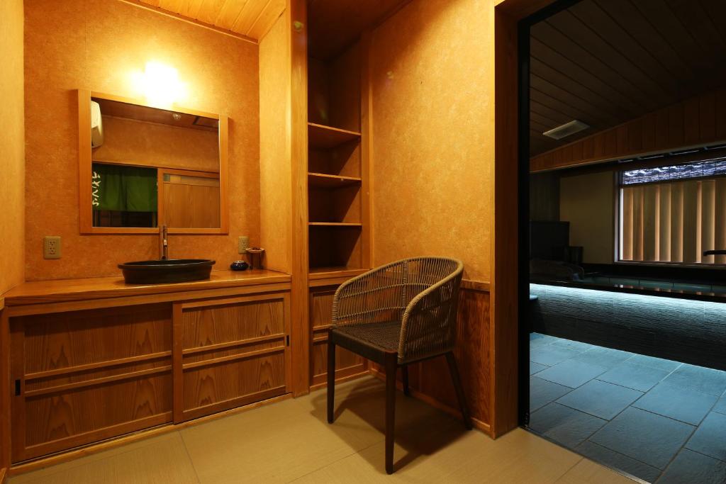 une salle de bain avec un lavabo et un miroir dans l'établissement Ichidaya, à Toyooka