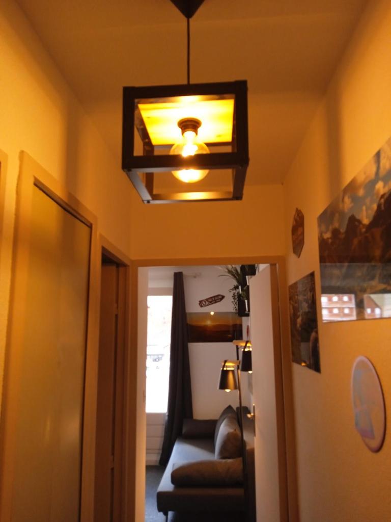 une lampe suspendue au plafond dans une chambre avec un canapé dans l'établissement Résidences de Mélisa La Foux d'Allos, à La Foux 16 autres photos