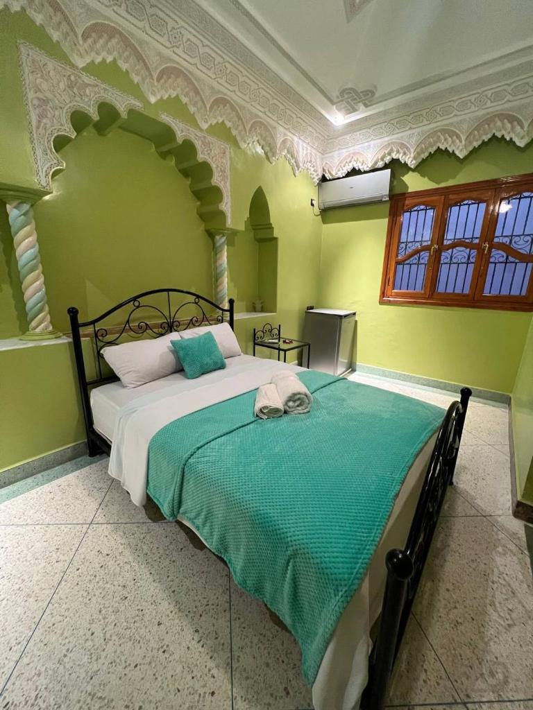 une chambre avec un grand lit aux murs verts dans l'établissement Riad Perlamazigh, à Zagora 28 autres photos