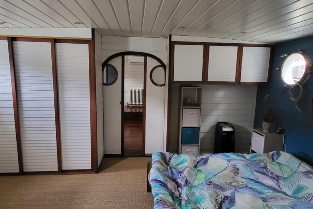 une chambre avec un lit dans une pièce avec des fenêtres dans l'établissement Appartement dans Péniche atypique et idyllique à Confluence, à Lyon