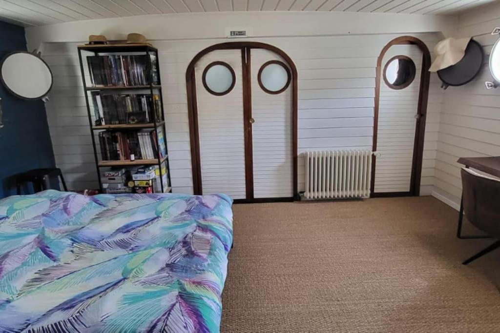 Cette chambre dispose de deux portes, d'un lit et d'une étagère. dans l'établissement Appartement dans Péniche atypique et idyllique à Confluence, à Lyon
