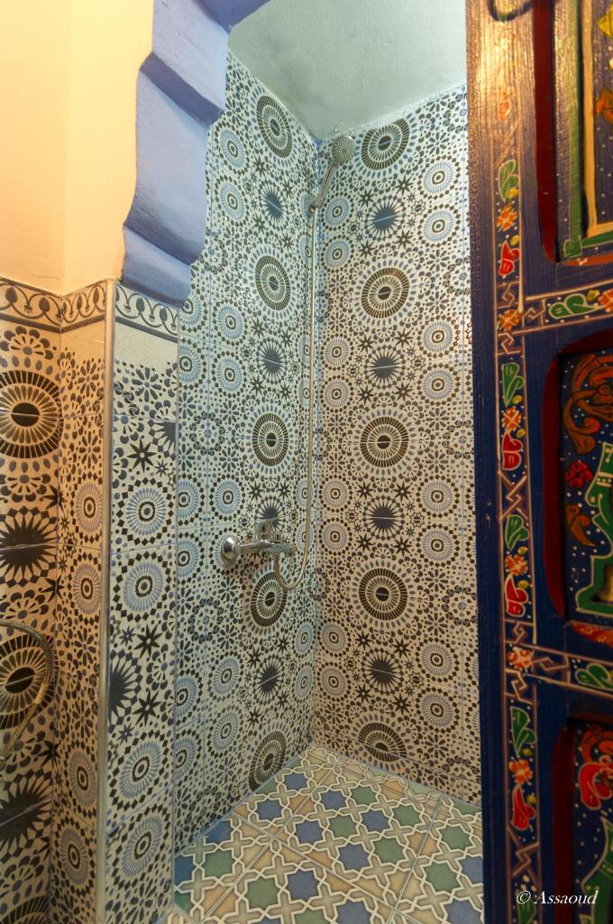 La salle de bains est pourvue d'une douche avec des motifs sur le mur. dans l'établissement Dar El Fanne, à Chefchaouen 35 autres photos