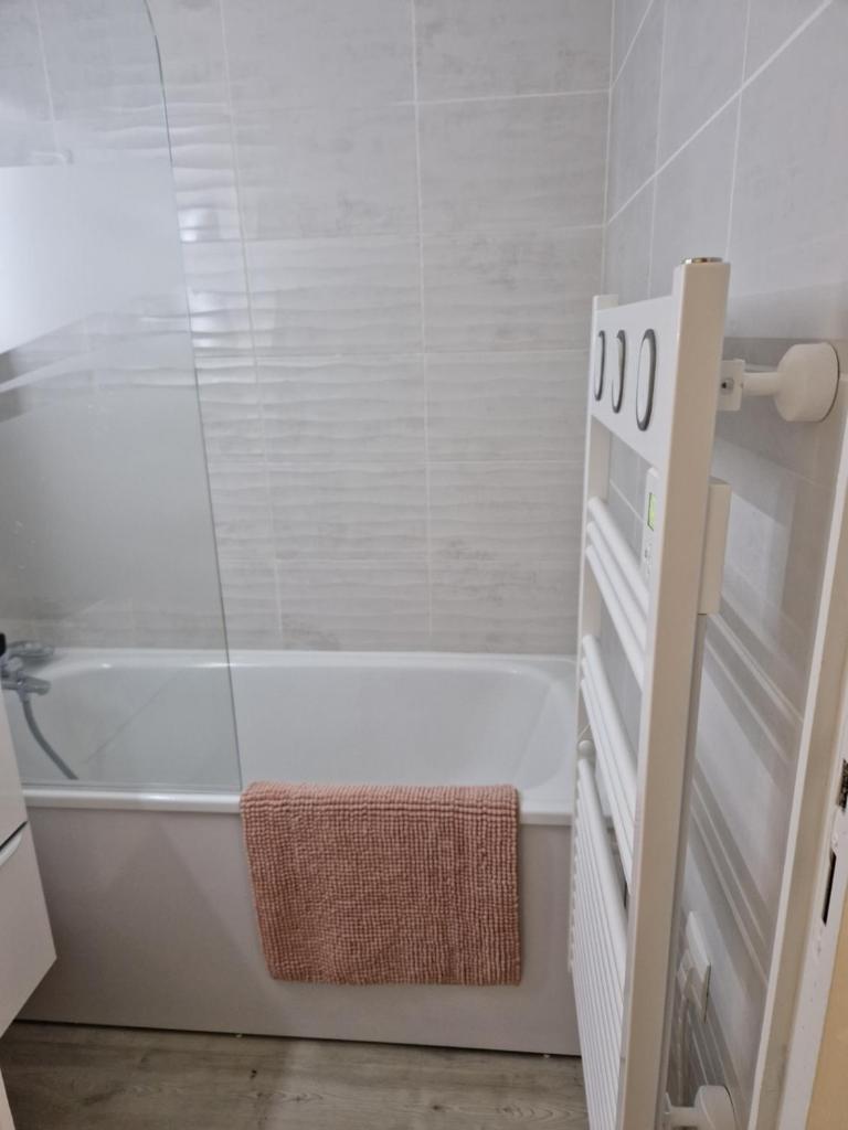 La salle de bains est pourvue d'une baignoire blanche et de carrelage blanc. dans l'établissement 2 pièce cabine Val Thorens, à Val Thorens 29 autres photos