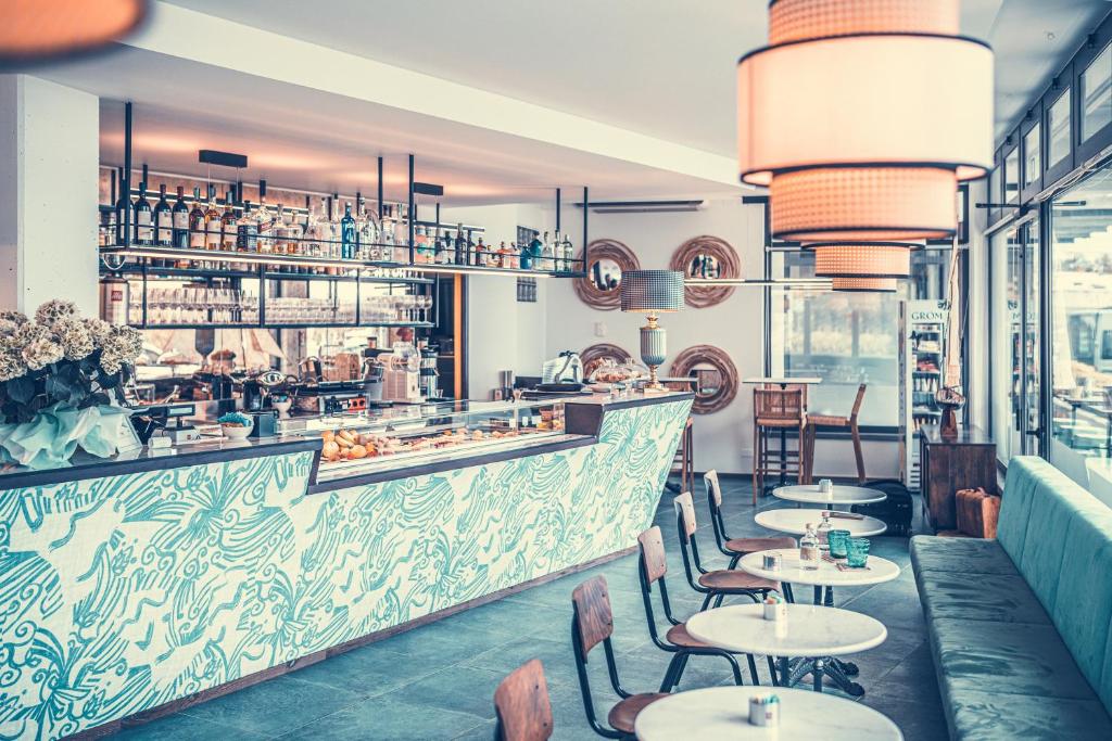 un restaurant avec des tables et des chaises et un bar dans l'établissement Club del Sole Tenuta Primero Hotel, à Grado