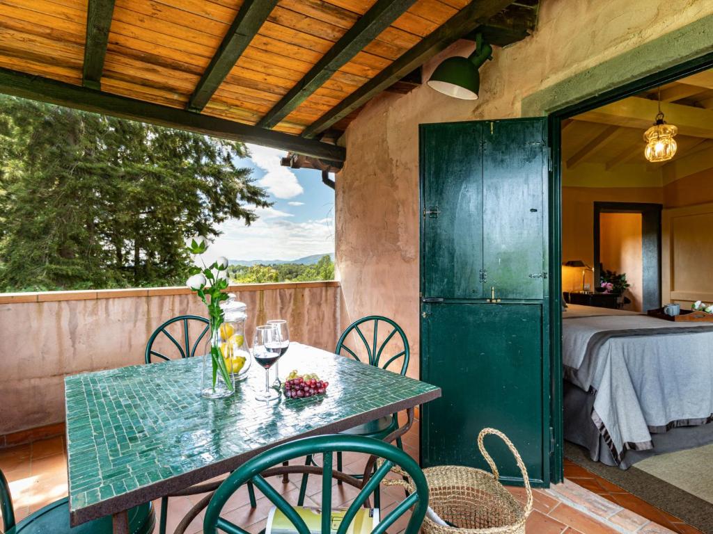un patio avec une table, des chaises et un lit dans l'établissement Villa La Torre - Fienile - Casa Prato by Interhome, à Figline Valdarno
