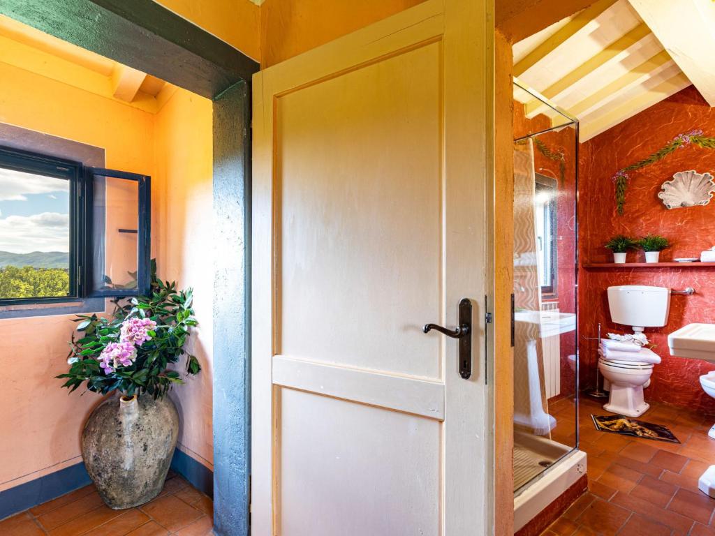 une salle de bain avec toilettes et un vase avec des fleurs dans l'établissement Villa La Torre - Fienile - Casa Prato by Interhome, à Figline Valdarno