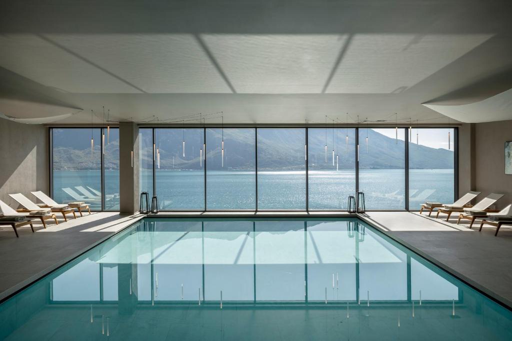 une piscine avec des chaises longues et une vue sur l'eau dans l'établissement EALA My Lakeside Dream - Adults Only, à Limone sul Garda