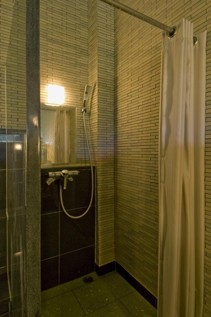une salle de bain avec une douche avec un rideau de douche dans l'établissement Nikko Tokanso, à Nikkō