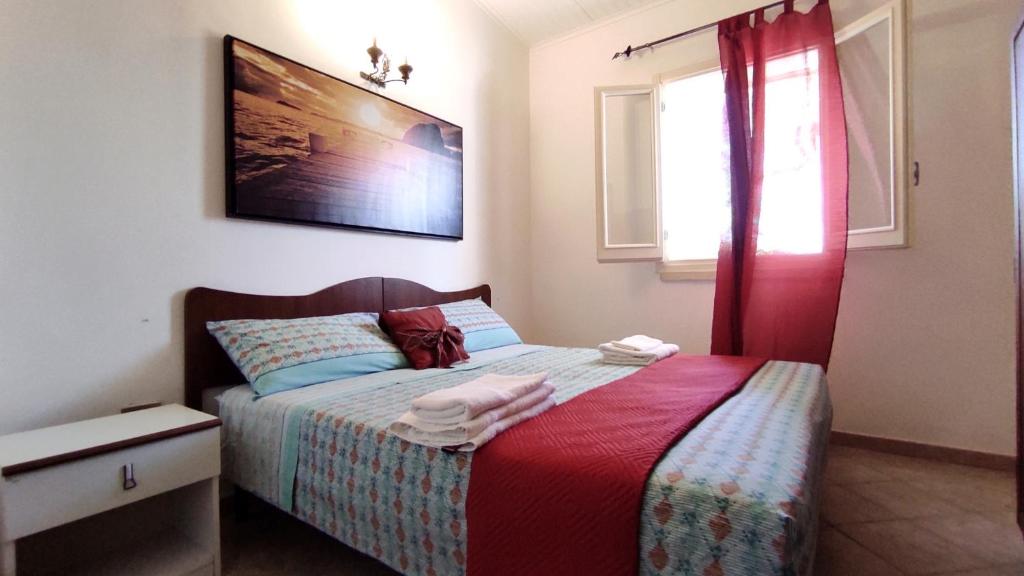 une chambre avec un lit avec un rideau rouge dans l'établissement Villa Piana - Con Piscina e Giardino privato nel Salento, à Tricase