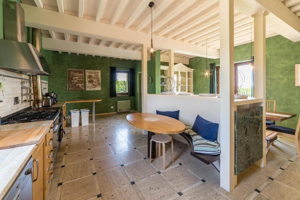 - une cuisine avec des murs verts et une table en bois dans l'établissement Villa Fragranza - Homelike Villas, à Buonconvento