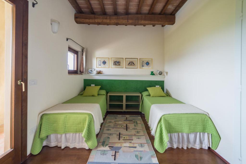 - 2 lits dans une chambre aux murs verts et blancs dans l'établissement Villa Fragranza - Homelike Villas, à Buonconvento