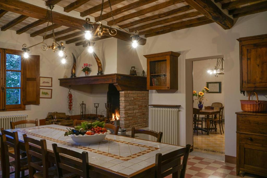 Il comprend une cuisine et une salle à manger avec une table et une cheminée. dans l'établissement Borgo La Pievina - Pool Villa, à Palazzina