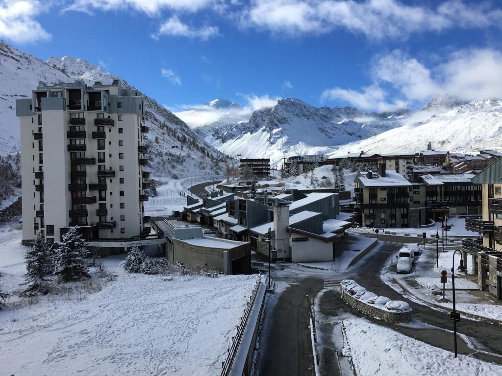une ville avec des bâtiments enneigés et une montagne dans l'établissement Studio rénové 2 adultes 2 enfants - Tignes Lavachet - Vue Montagne plein sud, à Tignes