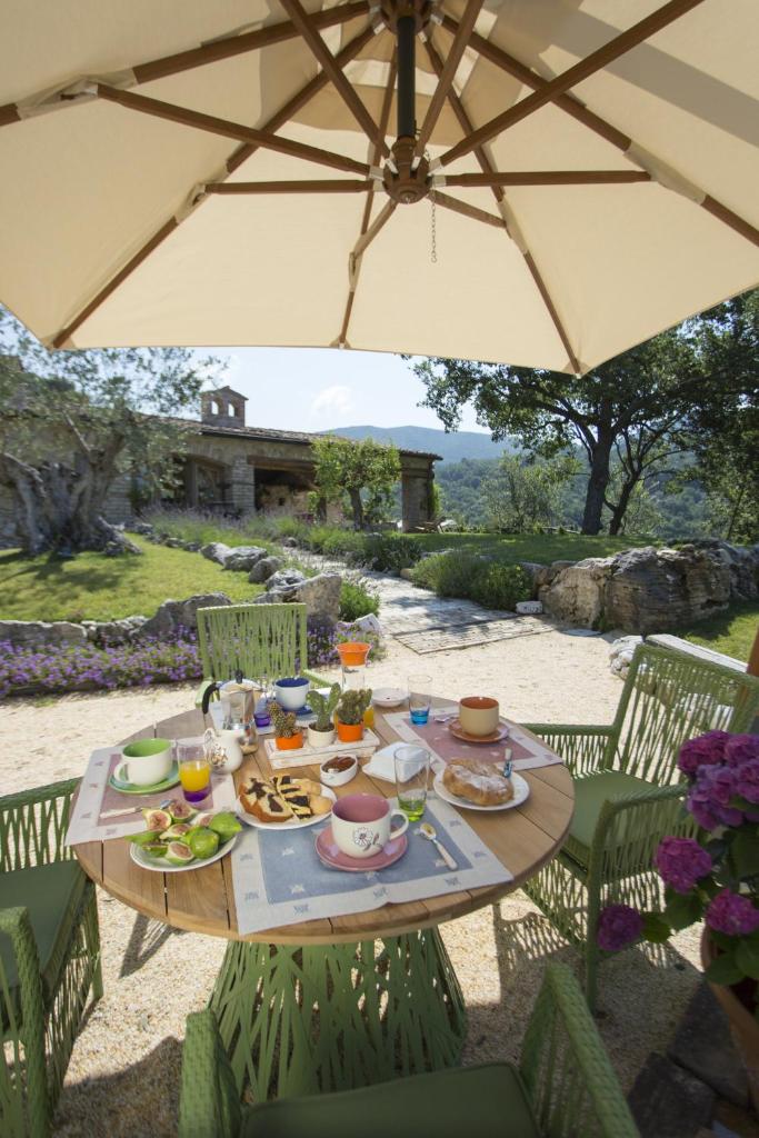une table avec de la nourriture sous un parapluie dans l'établissement Luxury villa Colle dell'Asinello ,proprietari ,Villa In esclusiva near ORVIETO, à Guardea