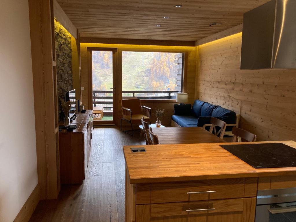 une cuisine et un salon avec un canapé et une table dans l'établissement Le Flocon - 6 personnes, à Saint-Chaffrey
