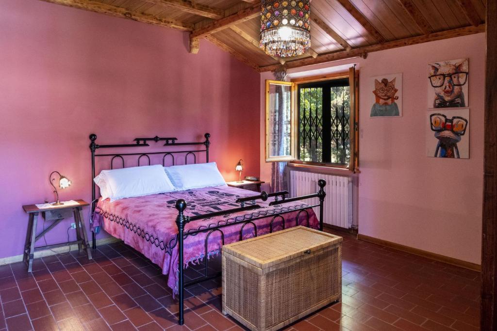 - une chambre avec un lit dans une pièce aux murs roses dans l'établissement Villa Laura - Private Pool Near Acqualagna, à Smirra