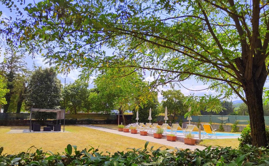 un parc avec une rangée de chaises et une piscine dans l'établissement Villa Laura - Private Pool Near Acqualagna, à Smirra