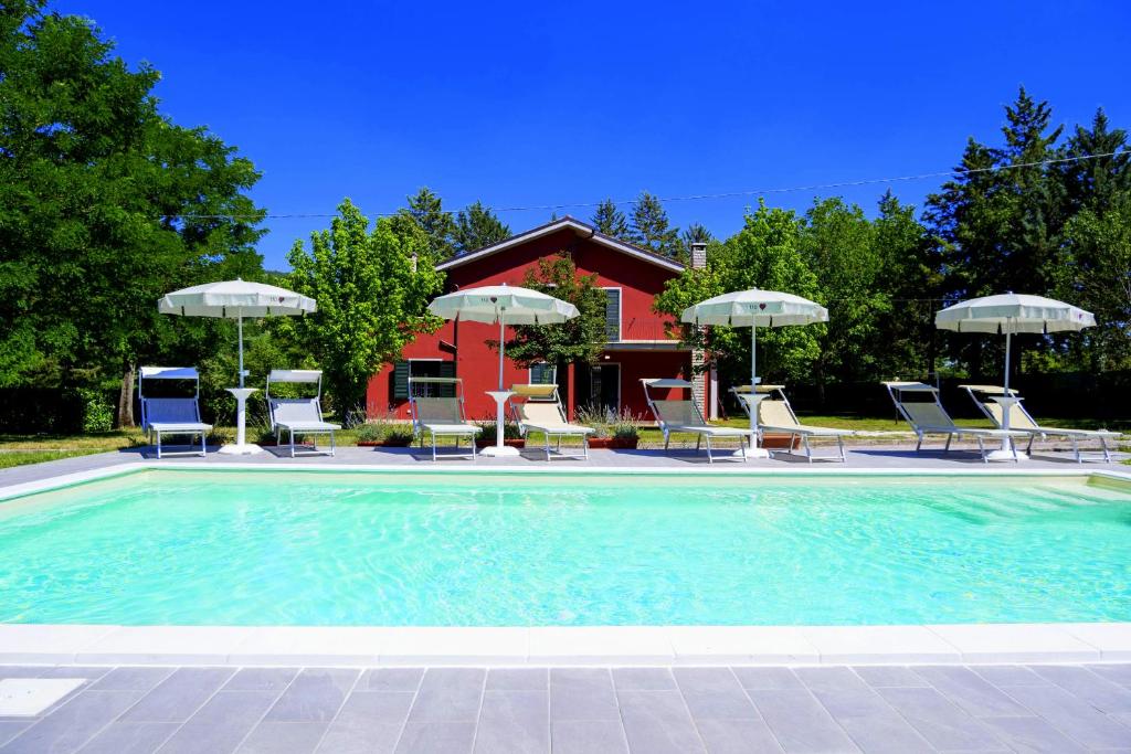 une piscine avec chaises et parasols dans l'établissement Villa Laura - Private Pool Near Acqualagna, à Smirra