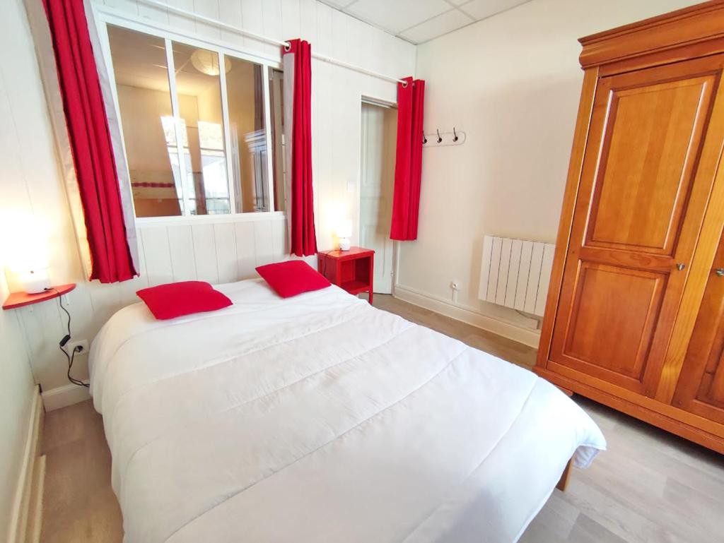 - une chambre avec un grand lit blanc et des rideaux rouges dans l'établissement Les 3 renards, T2 bis, parking, centre Luchon, casier à skis, 4 personnes, à Luchon