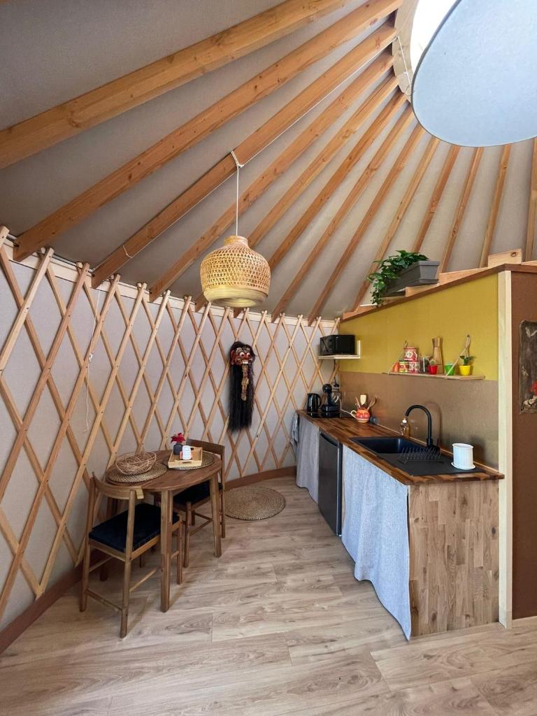 - une cuisine avec une table dans une yourte dans l'établissement Yourte ,volcans,randonnées,lacs,quiétude, à Grandeyrolles
