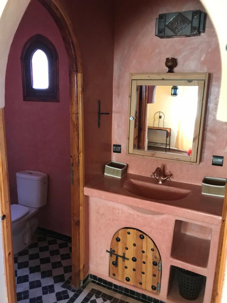 une salle de bain avec un lavabo et un miroir dans l'établissement Riad Moha, à Merzouga 37 autres photos