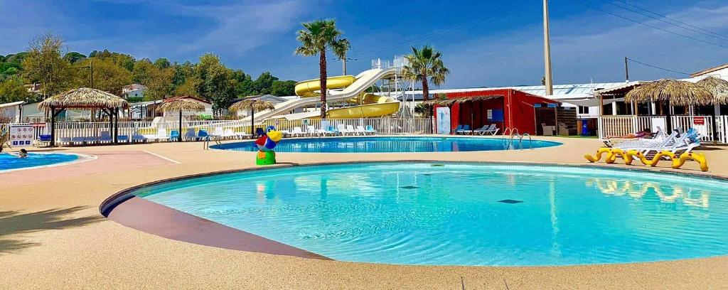 un parc aquatique avec un toboggan en arrière-plan dans l'établissement Mobil-Home Victory Camping Siblu 4****, à Fréjus