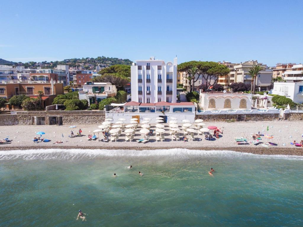 un groupe de personnes dans l'eau sur une plage dans l'établissement Hotel Del Sole, à Santa Marinella