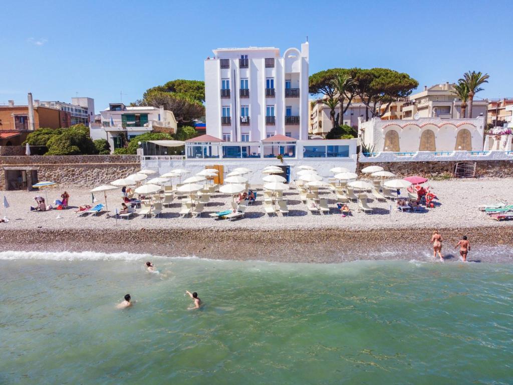 un groupe de personnes dans l'eau sur une plage dans l'établissement Hotel Del Sole, à Santa Marinella