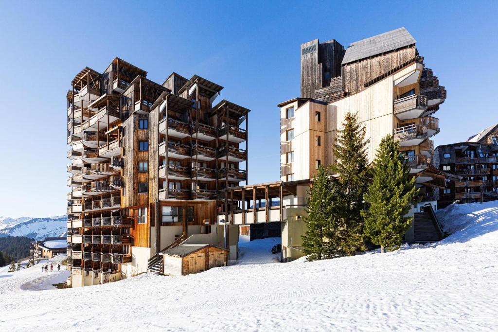 un bâtiment dans la neige à côté d'un autre bâtiment dans l'établissement Chalet Chamois - central modern Duplex for 6 by Avoriaz Chalets, à Avoriaz