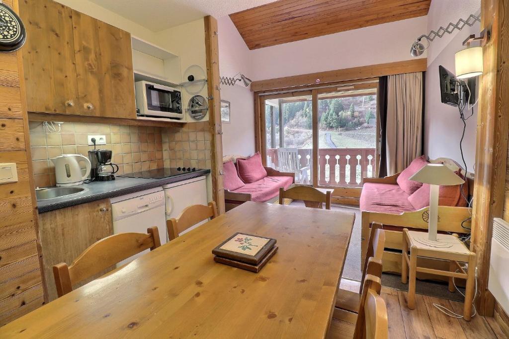 une cuisine et un salon avec une table en bois, une cuisine et une salle à manger dans l'établissement Residence Pralin, à Méribel