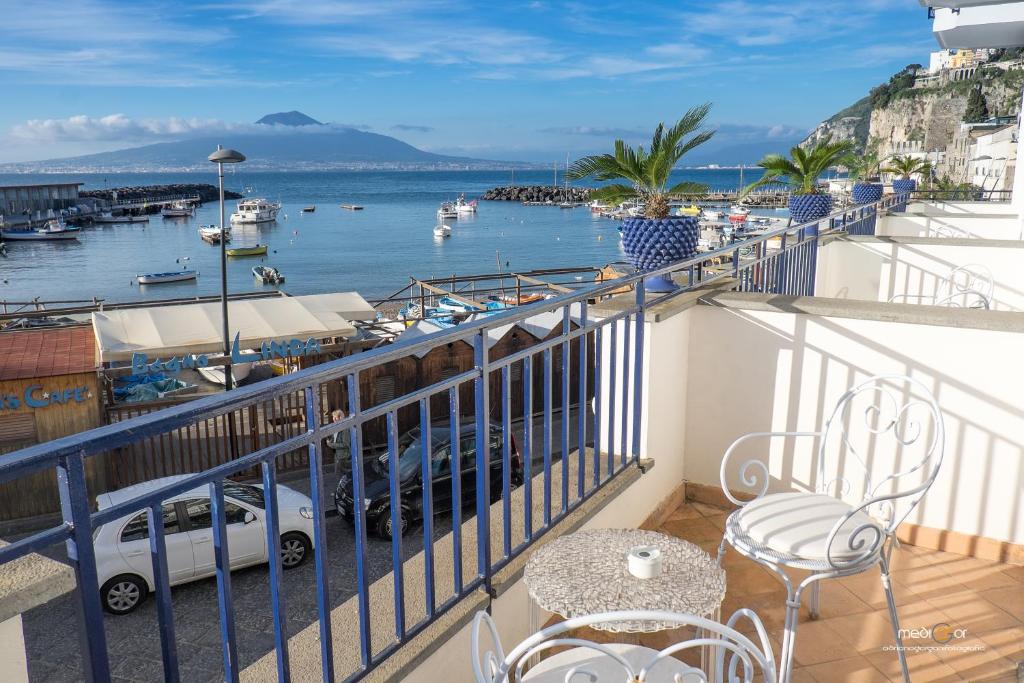 un balcon avec une table et des chaises et une vue sur un port dans l'établissement Le Ancore Hotel, à Vico Equense