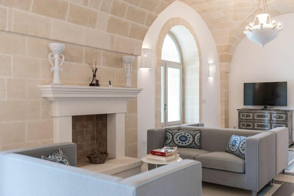 un salon avec un canapé et une cheminée dans l'établissement Villa Bellavista by Raro Villas, à Ostuni