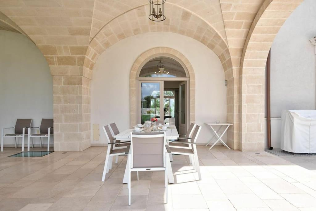 une salle à manger avec une table et des chaises blanches dans l'établissement Villa Bellavista by Raro Villas, à Ostuni